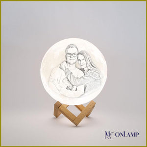 Image of couple engraved in small personalized moon lamp with wooden stand