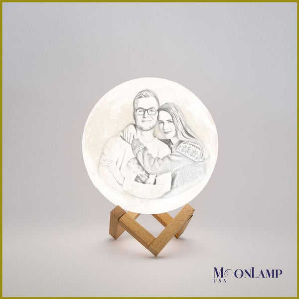 Image of couple engraved in small personalized moon lamp with wooden stand